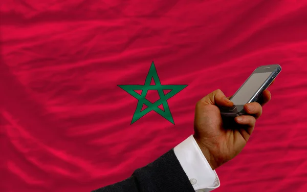 Mobiele telefoon in front nationale vlag van Marokko — Stockfoto
