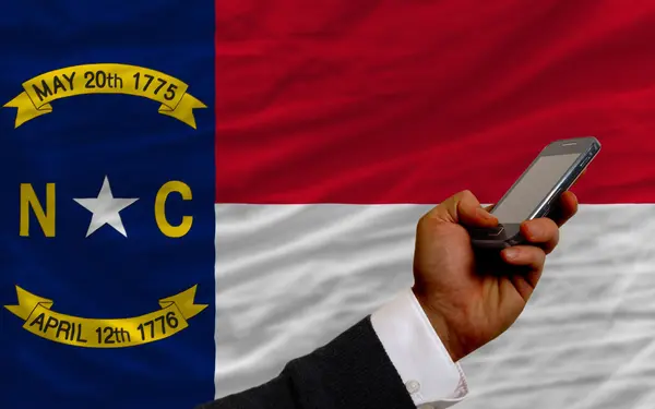 Mobiele telefoon in de voorkant vlag van de Amerikaanse staat north carolina — Stockfoto