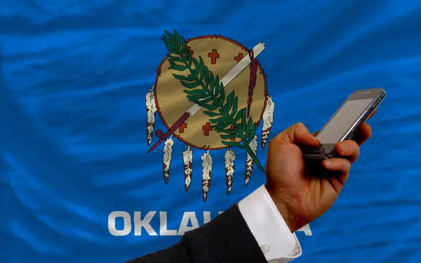 Cellulare davanti alla bandiera dello stato americano dell'oklahoma — Foto Stock