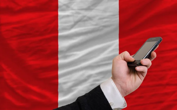 Handy vor der peruanischen Nationalflagge — Stockfoto