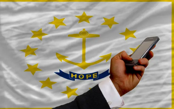 Teléfono celular en frente de la bandera del estado americano de Rhode Island — Foto de Stock