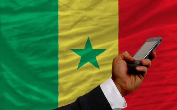 Telefone celular na frente bandeira nacional do Senegal — Fotografia de Stock