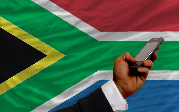 Mobiele telefoon in front nationale vlag van Zuid-Afrika — Stockfoto