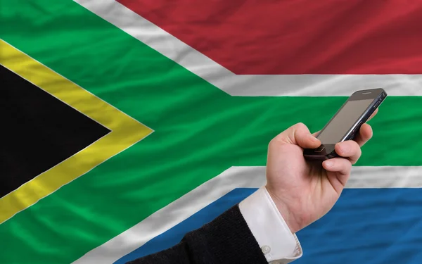 Mobiele telefoon in front nationale vlag van Zuid-Afrika — Stockfoto