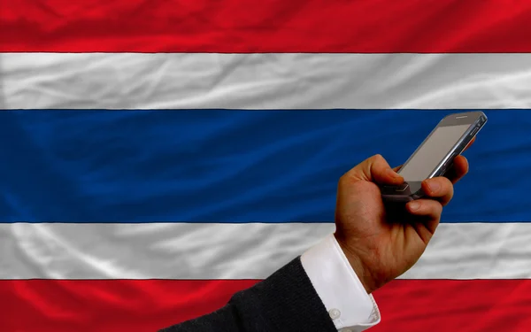 Mobiele telefoon in front nationale vlag van thailand — Stockfoto