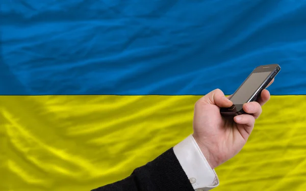 Mobiltelefon i främre nationella flagga Ukraina — Stockfoto