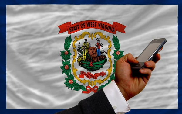 Handy vor Flagge des amerikanischen Bundesstaates Westvirginia — Stockfoto