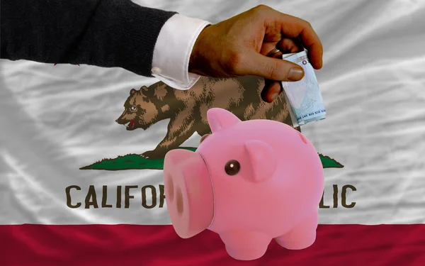 Dollar in piggy rijke bank en vlag van Amerikaanse staat van calif — Stockfoto