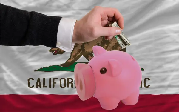 Dollar in piggy rijke bank en vlag van Amerikaanse staat van calif — Stockfoto