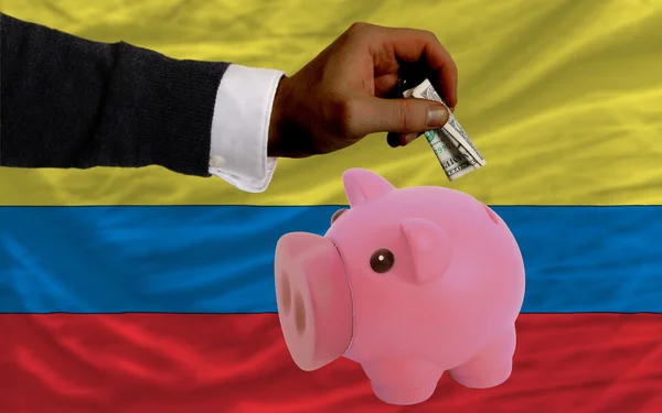 Dollar into piggy rich bank and national flag of columbia — Stock Photo, Image
