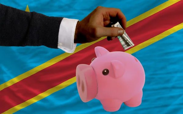 Dollar in piggy rijke bank en de nationale vlag van Congo — Stockfoto