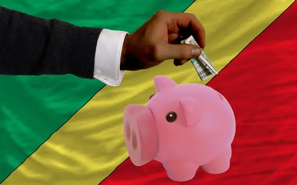 Dollar in piggy rijke bank en de nationale vlag van Congo — Stockfoto