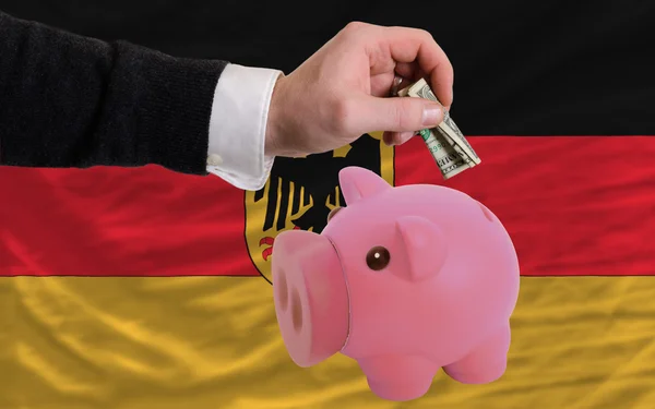 Dollar into piggy rich bank and national flag of germany — Stock Photo, Image