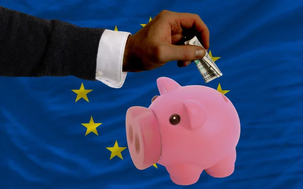 Dollar into piggy rich bank and national flag of europe — Stock Photo, Image