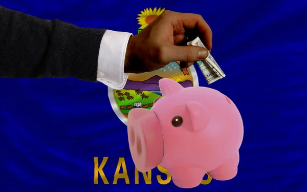 Dollar in piggy rijke bank en vlag van Amerikaanse staat van Kansas — Stockfoto