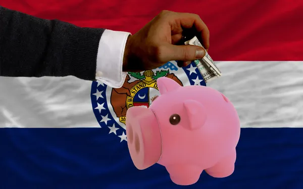 Dollar into piggy rich bank and flag of american state of misso — Stock Photo, Image