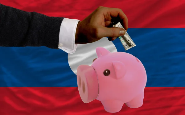 Dólar em porquinho rico banco e bandeira nacional do laos — Fotografia de Stock
