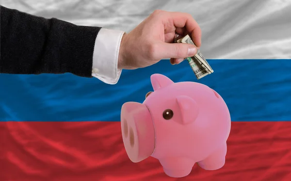 Dollar in Sparschwein und russische Nationalflagge — Stockfoto