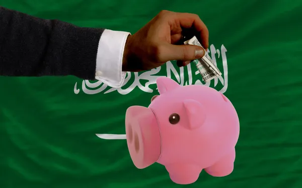 Dollar into piggy rich bank and national flag of of saudi arab — Stock Photo, Image