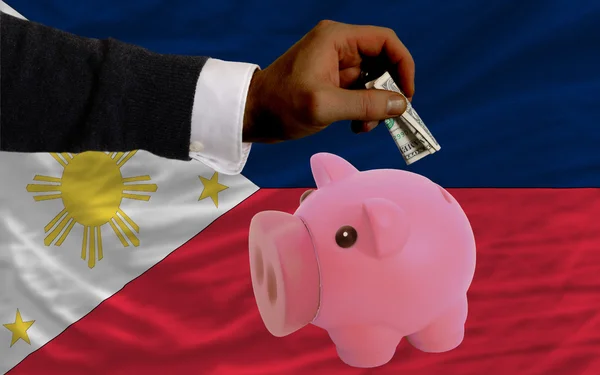 Dólar em porquinho rico banco e bandeira nacional de filipinas — Fotografia de Stock