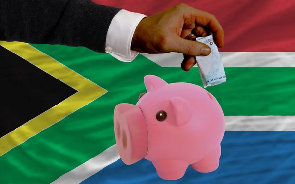 Funding euro into piggy rich bank national flag of south africa — Stock Photo, Image