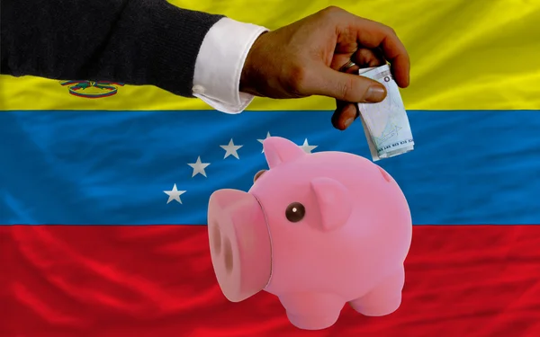 Funding euro into piggy rich bank national flag of venezuela — Stock Photo, Image