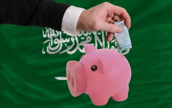 Funding euro into piggy rich bank national flag of of saudi ara — Stock Photo, Image