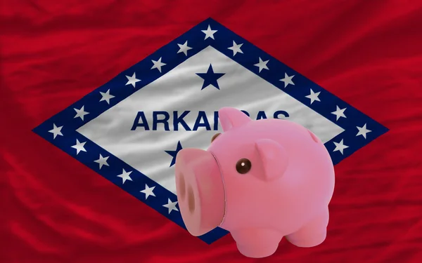 Piggy rich bank and flag of american state of arkansas — Stock Photo, Image