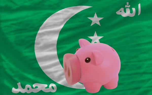Piggy rich bank and national flag of comoros — стоковое фото