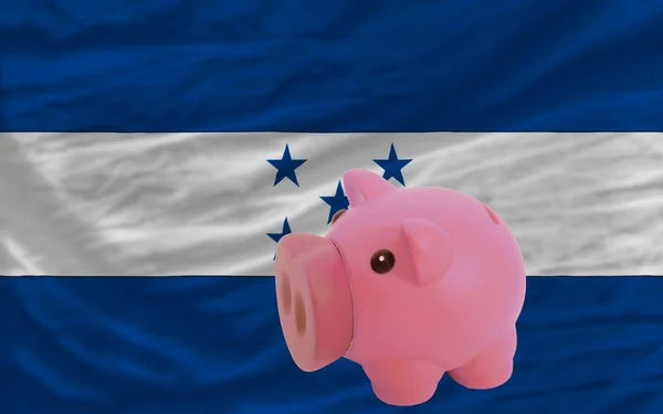 Piggy rich bank and national flag of honduras — Stock Photo, Image