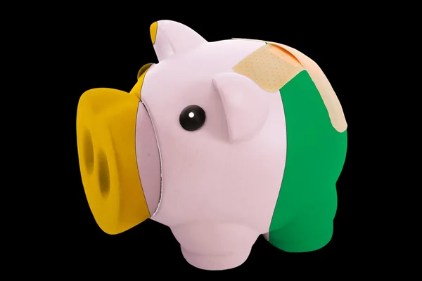 Bankrupt piggy rich bank in colors of national flag of cote ivor — Stock Photo, Image