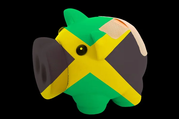 Banco rico porquinho falido em cores da bandeira nacional de jamaica — Fotografia de Stock