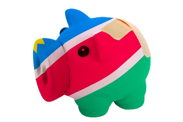 Closed piggy rich bank with bandage in colors national flag of n — Stock Photo, Image