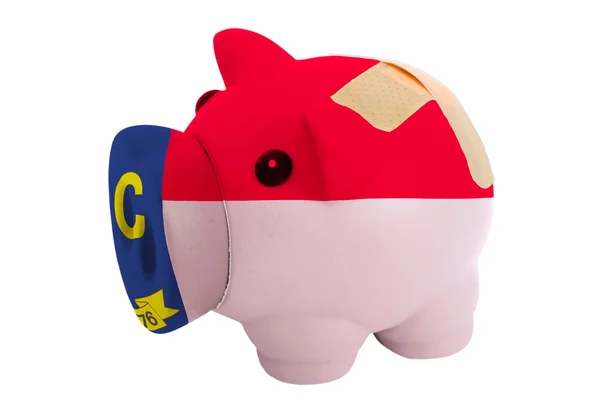 Closed piggy rich bank with bandage in colors flag of american s — Stock Photo, Image