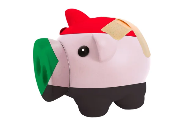 Closed piggy rich bank with bandage in colors national flag of s — Stock Photo, Image