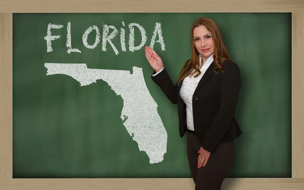 Teacher showing map of florida on blackboard — Stock Photo, Image