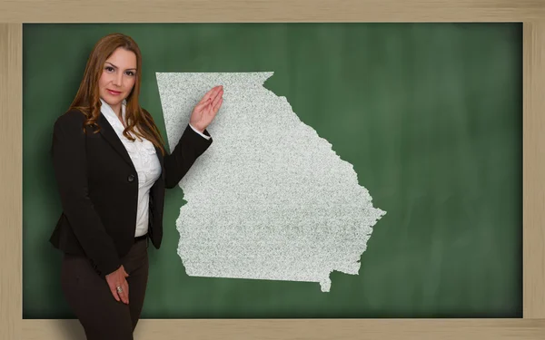 Teacher showing map of georgia on blackboard — Stock Photo, Image