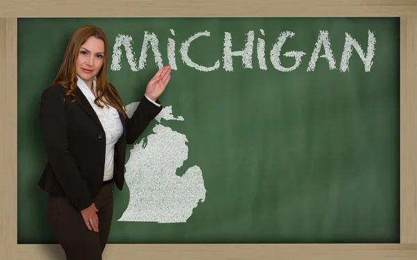 Teacher showing map of michigan on blackboard — Stock Photo, Image