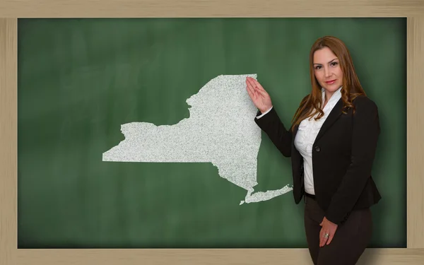 Teacher showing map of new york on blackboard — Stock Photo, Image