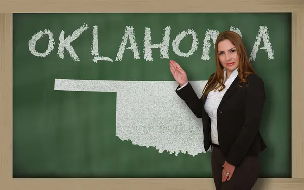 Teacher showing map of oklahoma on blackboard — Stock Photo, Image