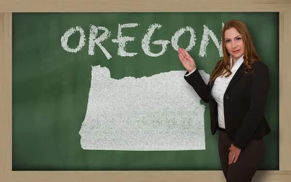 Teacher showing map of oregon on blackboard — Stock Photo, Image