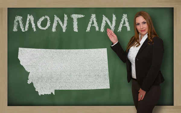 Teacher showing map of montana on blackboard — Stock Photo, Image