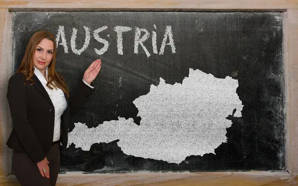 Teacher showing map of austria on blackboard — Stock Photo, Image