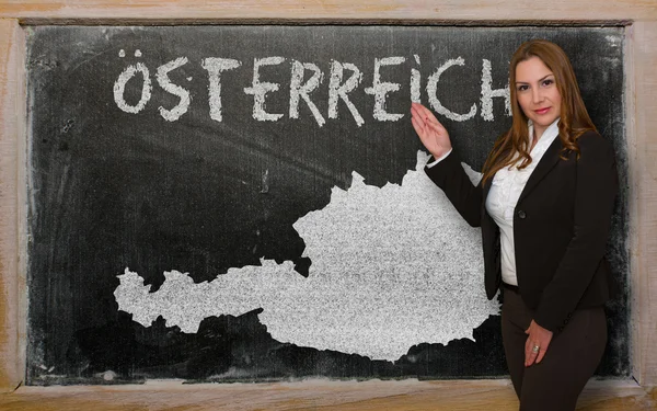 Teacher showing map of austria on blackboard — Stock Photo, Image