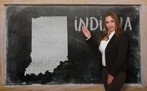 Teacher showing map of indiana on blackboard — Stock Photo, Image