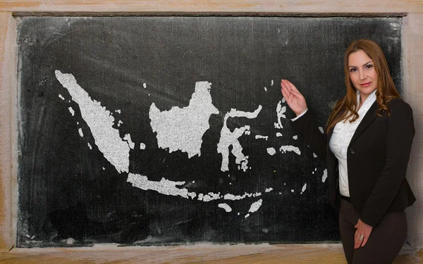 Teacher showing map of indonesia on blackboard — Stock Photo, Image