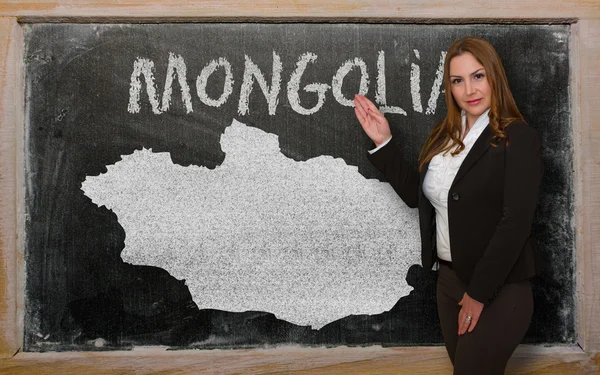 Teacher showing map of mongolia on blackboard — Stock Photo, Image