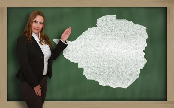 Teacher showing map of zimbabwe on blackboard — Stok fotoğraf