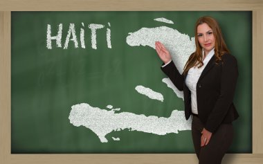 Teacher showing map of haiti on blackboard