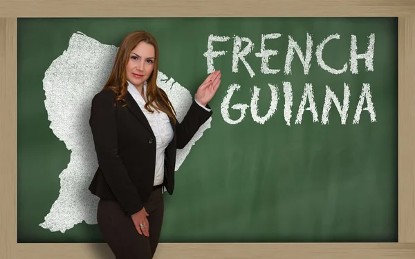 Teacher showing map of french guiana on blackboard — Stock Photo, Image